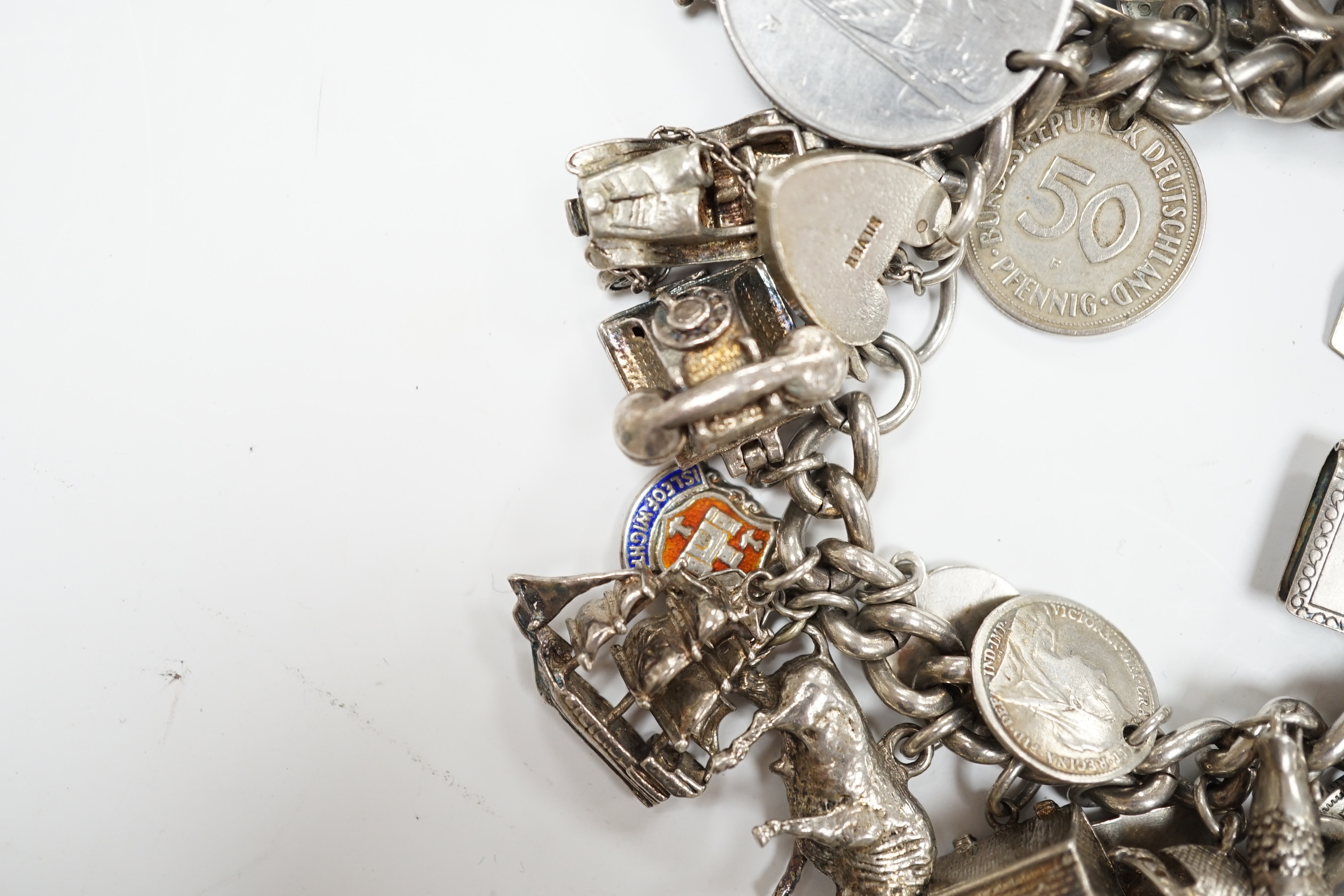 A silver charm bracelet, hung with assorted mainly white metal charms including tankard and Knight's helmet, two 'melted' ingots and a silver medallion.